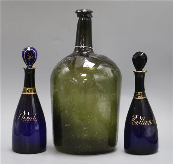 An 18th century large glass bottle and a pair of Bristol blue glass decanters, Hollands and Shrub tallest 33cm